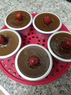 four cups with chocolate pudding and strawberries in them