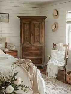 a bedroom with white walls and wooden furniture