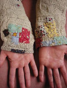 two hands wearing mittens made out of old cloth with patchwork and buttons on them