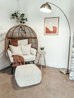 a chair and ottoman in a room with a lamp on the wall next to it