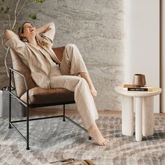 a woman sitting in a chair with her feet up on the table and looking up