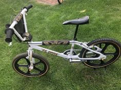 a white bicycle parked on top of a lush green field