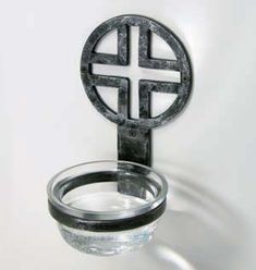 a metal object with a glass in it on a white surface and black ring around it