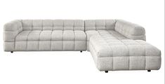 a large gray couch sitting next to a footstool on top of a white floor