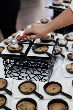 a table topped with lots of desserts on top of white plates and pans