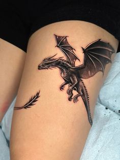 a woman's thigh with a dragon tattoo on it