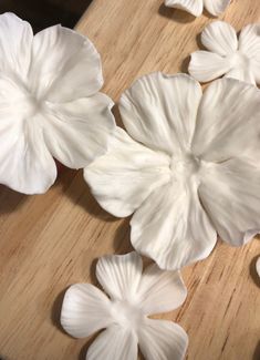 some white flowers sitting on top of a wooden table