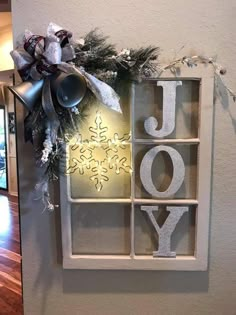 a decorated window with the word joy spelled out in letters and snowflakes on it