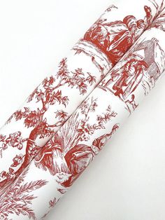 three rolls of red and white wrapping paper with images of people in the woods on them