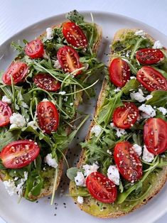 two slices of bread with tomatoes and feta cheese on them, sitting on a plate