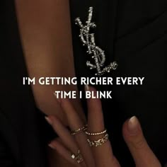 a woman's hand with two rings on it and the words i'm getting richer every time i blink