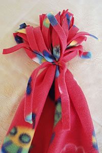 a red scarf with blue, yellow and pink flowers is laying on a white surface