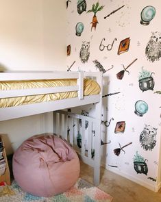 there is a bunk bed with a pink bean bag on the bottom and wallpaper behind it