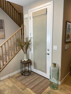 an entry way with a vase and plant on the floor