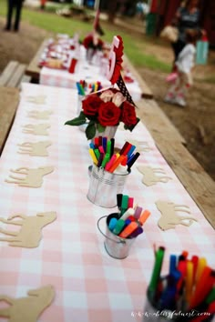 a long table is set up with flowers and candles for an outdoor birthday party or baby shower