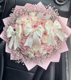 a bouquet of pink and white roses in a car