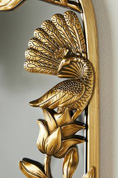 an ornate gold mirror with a bird on it