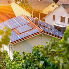 solar panels on the roof of houses in an urban area with trees and buildings behind them