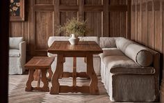 a living room with wood paneling and a couch in the corner next to a coffee table