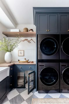 a washer and dryer in a laundry room with blue cabinets, checkered floor