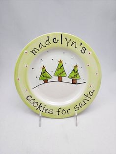 a green plate with trees on it and the words madelyn's cookies for santa