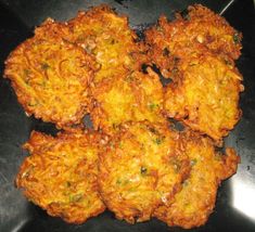 some fried food is on a black plate