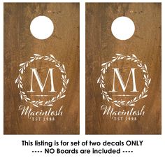 two wooden door hangers with monogrammed initials and laurel wreaths on them