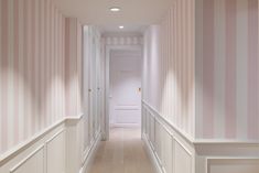 an empty hallway with pink and white striped walls