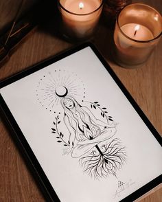 a lit candle and some candles on a table with a drawing in front of it