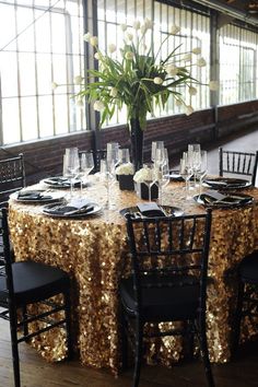 the table is set with gold sequins and black chairs