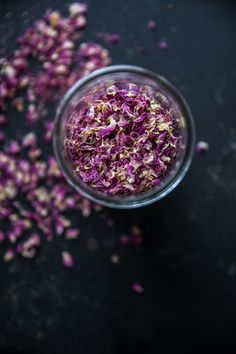 red cabbage sprinkled with gold flakes in a small glass bowl on a black surface