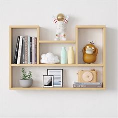 the shelves are filled with books, toys and other things on display in front of a white wall