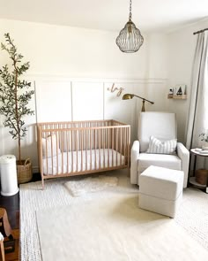 a baby's room with a crib, rocking chair and tree in the corner