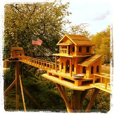 a wooden house on top of a bridge with an american flag flying in the background