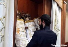 a man is looking through the closet with many items on display in front of him