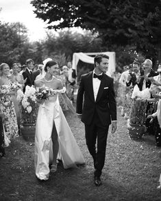 a bride and groom walk down the aisle as confetti is thrown around them