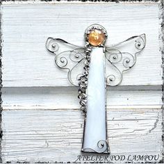 a white cross with an orange stone in the center on a wooden background that says, i believe god always