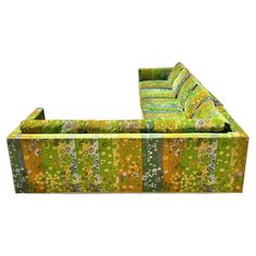 a green and yellow couch sitting on top of a white floor