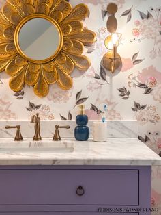 a bathroom vanity with two sinks and a large gold mirror on the wall above it