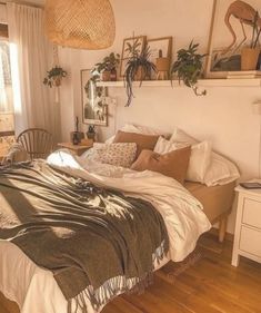 a bed sitting in a bedroom next to a window with potted plants on top of it