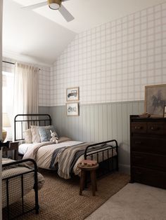 a bed room with two beds and a dresser next to a wallpapered wall