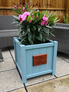 a blue planter with pink flowers in it