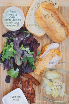 a cutting board topped with bread, salad and other foods