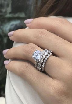 a woman's hand with two rings on her fingers and one ring in the middle