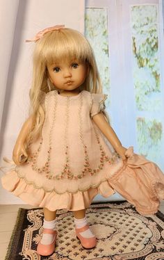 a doll with blonde hair is standing on a rug