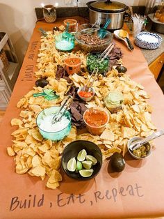 a table topped with lots of chips and dips