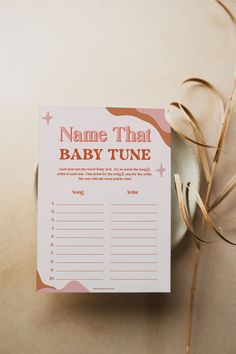 a baby tune card sitting on top of a table next to some dried grass and an empty bowl