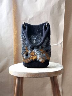 a purse sitting on top of a wooden stool