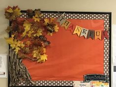 a bulletin board decorated with fall leaves