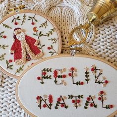 two embroidered hoop art pieces with the words felt nativity written in red and white